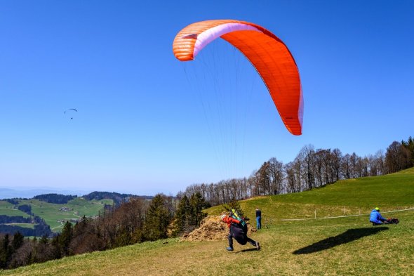 Hängegleiter Start Ein Hängegleiter startet von einer Holzrampe auf einem Berg